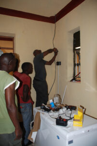 Timothy installing wiring for new refrigerator for medicine and vaccines at the new ward for the Health Centre.